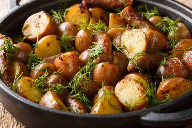 Sosisli, sarımsaklı ve dereotlu yeni kızartılmış bebek patatesler masanın üstünde. yatay