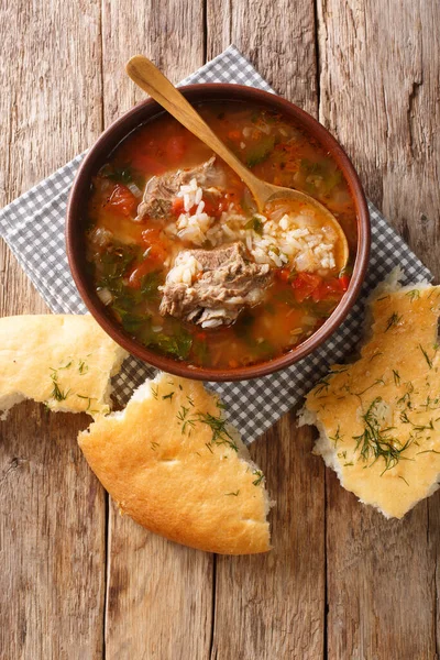 テーブルの上には 伝統的な牛肉と米のカルチョのスープにスパイスと野菜を添えたピタパンが並びます アボフからの垂直上の眺め — ストック写真