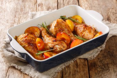 Erik sosunda pişirilmiş baharatlı tavuk bacağı ve masada yakın plan pişirme kabında biberiye. yatay