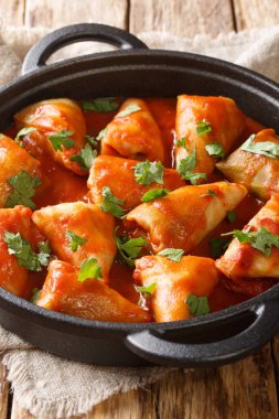 Etli lahana ruloları ve domates soslu pilav ve masanda maydanozu yakın plan bir kaseye koy. dikey