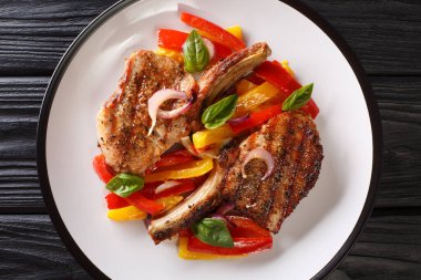 Restoran yemekleri ızgara domuz pirzolası ve beyaz tabakta sıcak dolmalık biber salatası. Yukarıdan yatay üst görünüm