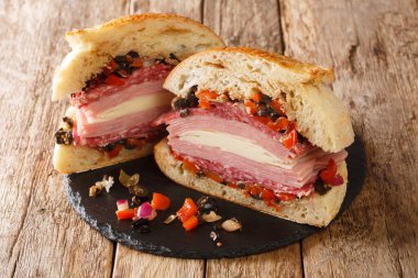 New Orleans Muffuletta Sandviçi. Bir sürü çeşit et ve peynirle üst üste yığılmış canavar bir sandviç. Ve masaya yakın bir zeytin salatası. Yatay