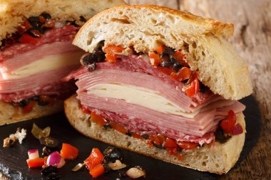 Otantik New Orleans Muffuletta sandviçi. İçi zeytin salatası, peynir, salam ve jambon dolu. Masanın üstünde. Yatay
