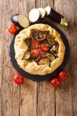 Domatesli, soğanlı ve otlu patlıcanlı turta. Masadaki tahtaya yakın plan. yukarıdan dikey üst görünüm