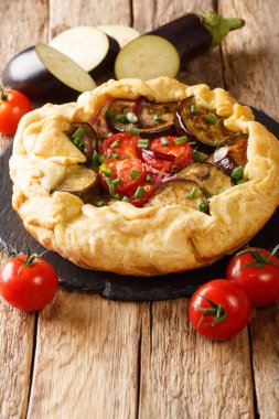 Domatesli, soğanlı ve otlu patlıcanlı turta. Masadaki tahtaya yakın plan. dikey
