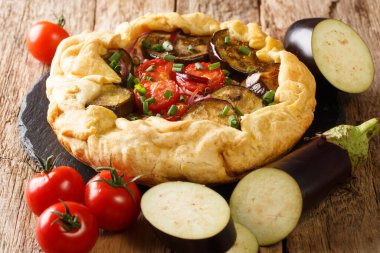 Domatesli, peynirli ve otlu kırsal patlıcan turtası masanın üzerindeki tahtaya yakın plan. yatay