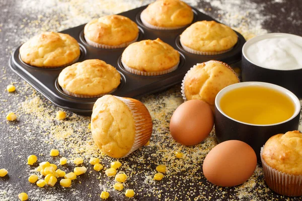 Recipe for corn muffins in a baking dish and ingredients close-up on the table. horizonta