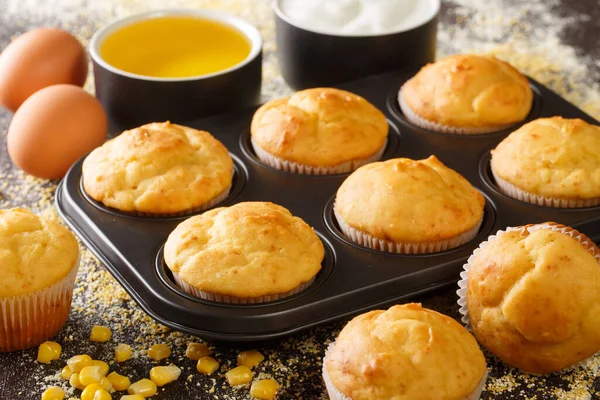 Homemade vegetarian corn muffins in a baking dish and ingredients close-up on the table. horizonta