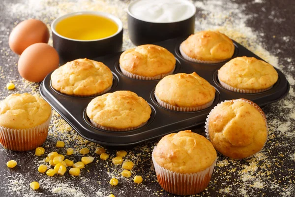 Healthy corn muffins in a baking dish and ingredients close-up on the table. horizonta