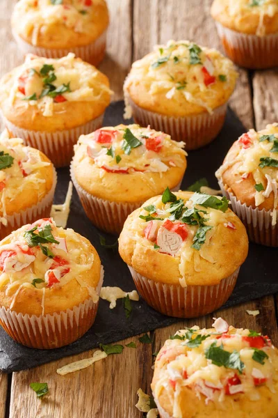 Corn muffins with crab meat and cheese close-up on a slate board on the table. vertica