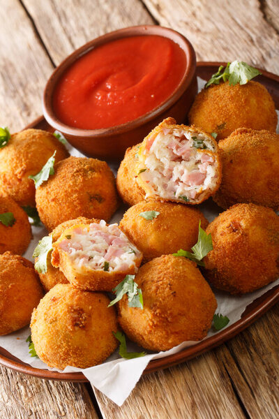 Deep fried sauerkraut balls with ham close-up in a plate on the table. vertica