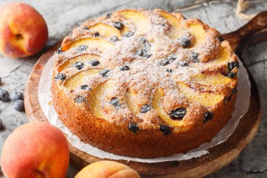 Masanın üzerinde taze şeftali ve yabanmersinli ev yapımı turta var. yatay