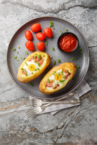 İki kez fırında patates, domuz pastırması ve yakın plan yumurta, masanın üstünde. yukarıdan dikey üst görünüm