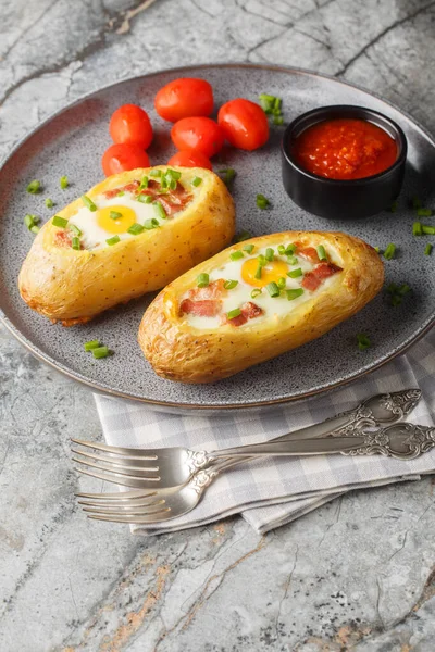 İki kez fırında patates, domuz pastırması ve yakın plan yumurta, masanın üstünde. dikey