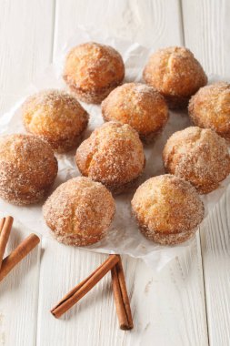 Tarçınlı şekerli çörekler ahşap masaya yakın çekim. Dikey