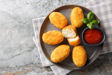 Lezzetli kızarmış kızarmış tavuk kroketleri. Masadaki tabakta domates sosuyla servis ediliyor. Yukarıdan yatay üst görünüm