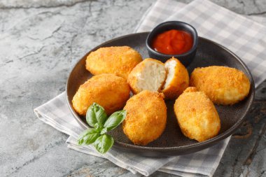 Lezzetli kızarmış kızarmış tavuk kroketleri. Masadaki tabakta domates sosuyla servis ediliyor. Yatay