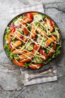 Bufalo doğranmış tavuklu salata ve sulu ızgara tavuk. Masadaki tüm lezzetli malzemelerle karıştırılmış. Yukarıdan dikey üst görünüm