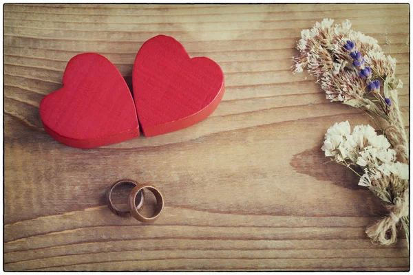 Valentines day concept. Two red hearts with two wooden wedding rings symbolize endless love of two persons.