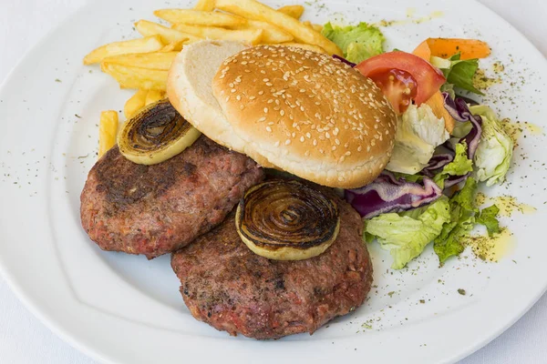 Burger with chips on white plate on white background