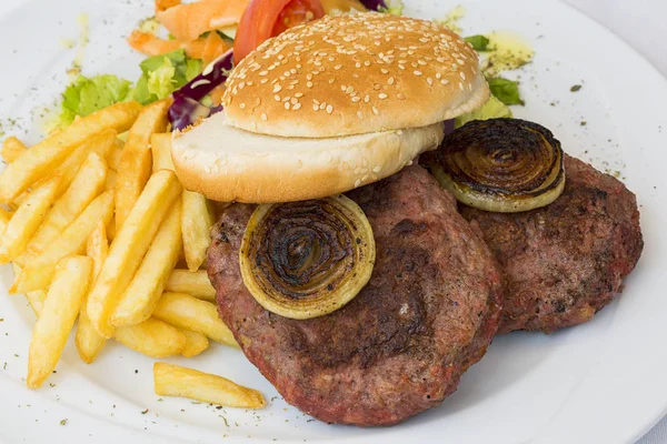 Burger with chips on white plate on white background