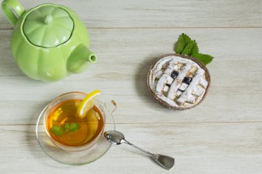 Ferahlık çalışma günü kavramı: bitkisel linden çay, beyaz zemin üzerine elmalı turta. Düz yatıyordu
