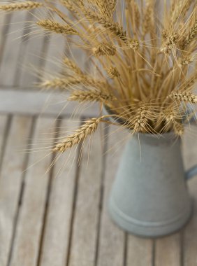 Buğday ahşap arka plan üzerinde gri vazoda buket