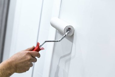 Dekoratörün el boyası silindirle duvarı 