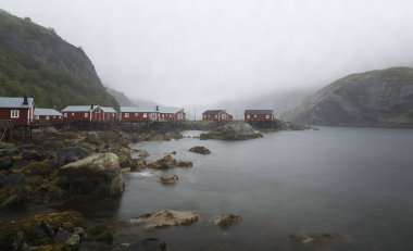 Geleneksel kırmızı ahşap evler, Yağmurlu bir günde Norveç, Nusfjord küçük balıkçı köyünde tipik yağmurlu havalarda Rorbuer.