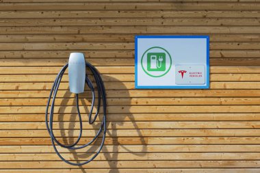 Nisan 02.2018, Bavyera, Almanya: Tesla elektrikli araç şarj istasyonu ahşap alp tarzında. Tesla işareti ve sembol. Boşluğu kopyala.