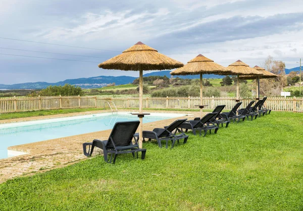 Yüzme Havuzu güneş şemsiyeleri ve sandalyeler — Stok fotoğraf