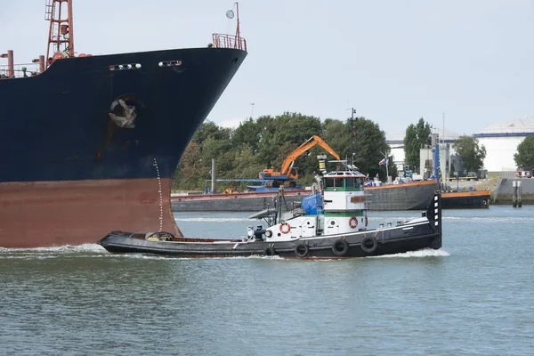 Small tug boat pulling big ship — Stock Photo, Image