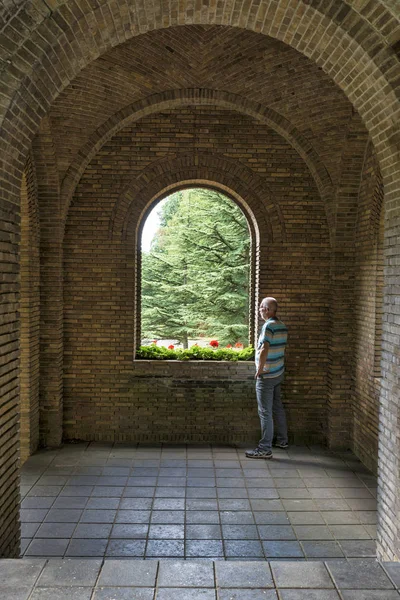 Mann blickt durch alten Wandkorridor nach draußen — Stockfoto
