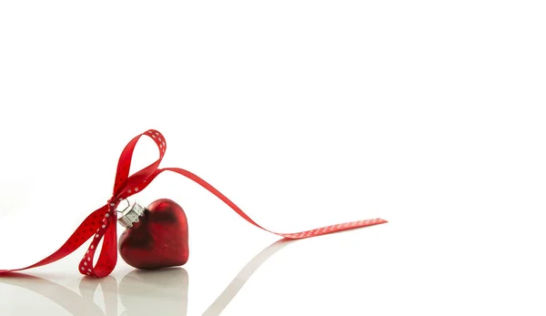 Coração vermelho de Natal com um arco de uma faixa vermelha — Fotografia de Stock