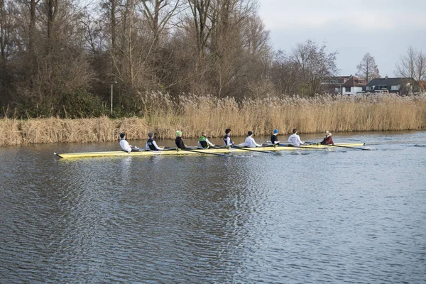 Acht mensen roeien in een baot — Stockfoto