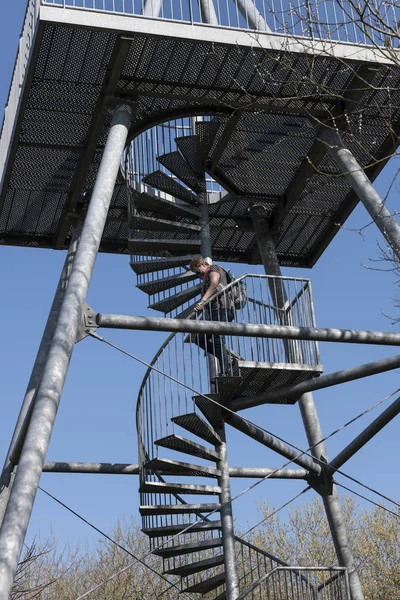 Vuxen kvinna clinbing ner för trappan en metall Vakttornet — Stockfoto