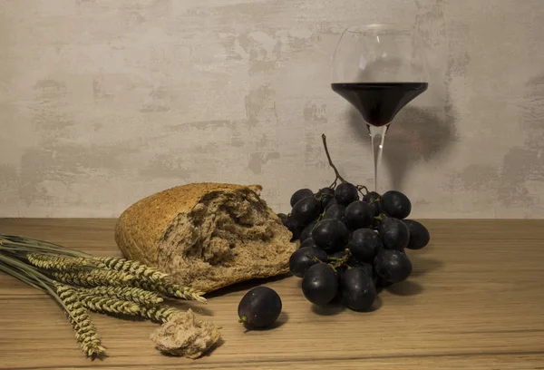 Un pane di grano e uva rossa con vino — Foto Stock