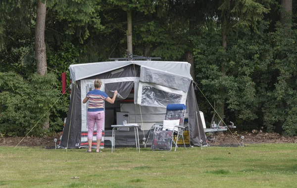 Frau installiert Dachkarawane auf einem Campingplatz — Stockfoto