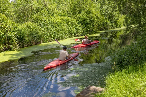 Man and woman conoeing in a canoe on a river in green nature in the netherlands — Stock Photo, Image