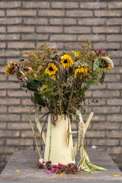 bouquet of dry flowers in yellow watering can