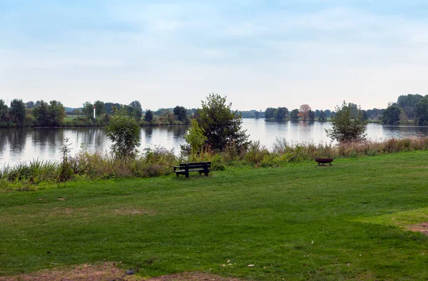 The river maas in holland with bench and fireplace — Stock Photo, Image