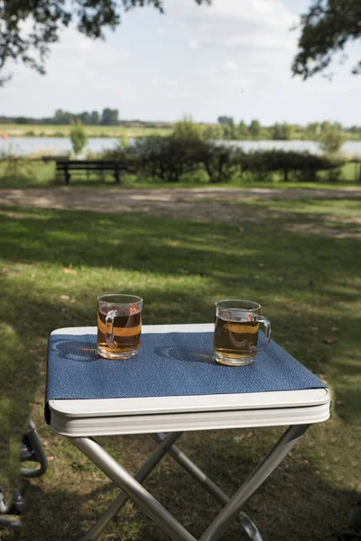 Two glasses of tea outside on a table on the river Maas — Stock Photo, Image