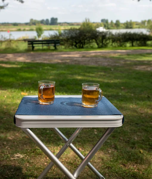 Two glasses of tea outside on a table on the river Maas — Stock Photo, Image