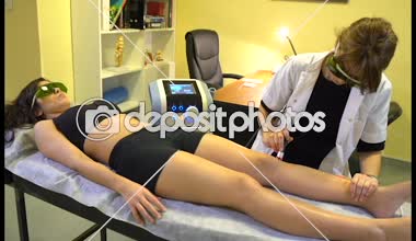 Fisiyoterapist bir kadının dizine yüksek yoğunluklu lazer uyguluyor. Diz kinesiologa fisiatra aplica lazer de alta intensidad BTL rodilla de mujer.