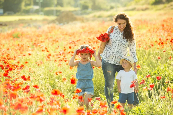 彼女の家族とケシ畑でブルネットの笑顔 散歩中の母親と子供たち ライフスタイル写真 — ストック写真