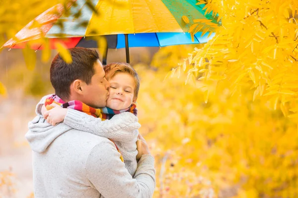 Küçük Bir Çocuk Babası Renkli Bir Şemsiye Altında Sıcak Giysili — Stok fotoğraf