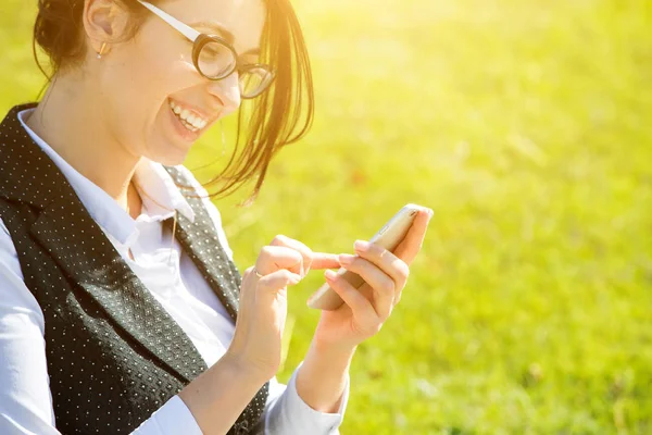 Kadını Artı Beden Elinde Akıllı Bir Telefonla Yeşil Çimlerin Arkasında — Stok fotoğraf