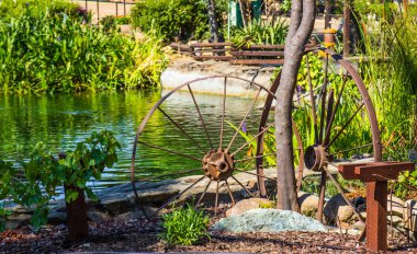 Çiftlik alanı gölet yanında iki paslı Metal tekerlekler