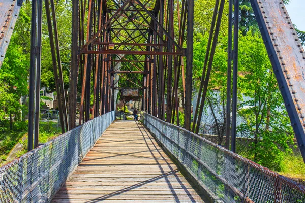 Old Weathered Walking Bridge Over River