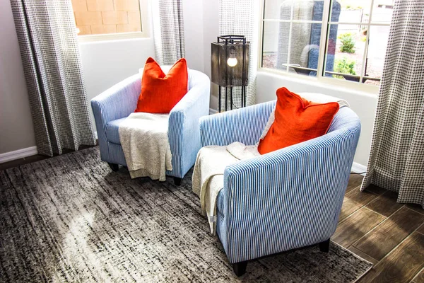 Two Barrel Chairs With Orange Pillows